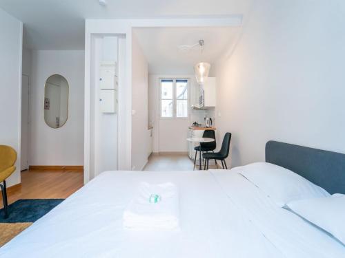 une chambre blanche avec un lit et un bureau dans l'établissement Charming studio- 2P- Jardin des plantes Austerlitz, à Paris