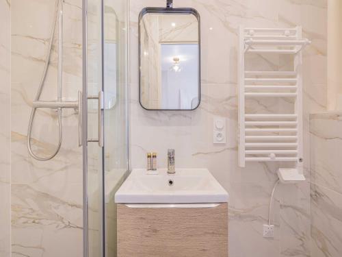 une salle de bain avec un lavabo et un miroir dans l'établissement Cosy studio for 2P - Le Bon Marché, à Paris