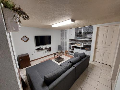Una sala de estar con un sofá y un televisor de pantalla plana. en Casa Bugambilia Guanajuato, en Guanajuato
