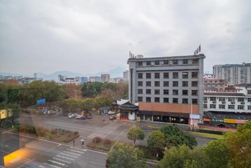 a large building in a city with a parking lot at Zhangjiajie Homeinn Boutique Hotel in Zhangjiajie