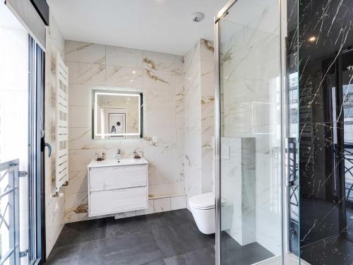 une salle de bain avec toilettes et douche en verre dans l'établissement Studio Sleek & Refined - Levallois-Perret, à Levallois-Perret