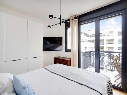 une chambre avec un lit et une grande fenêtre dans l'établissement Studio Sleek & Refined - Levallois-Perret, à Levallois-Perret
