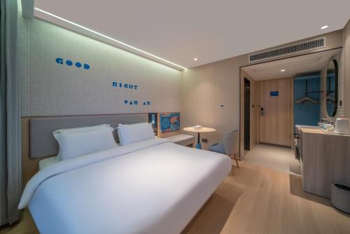 a bedroom with a large white bed and a desk at Zhangjiajie Homeinn Boutique Hotel in Zhangjiajie