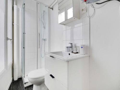 une salle de bain blanche avec des toilettes et un lavabo dans l'établissement Modern apartment - 1BR 4P - Sacré-C ur, à Paris