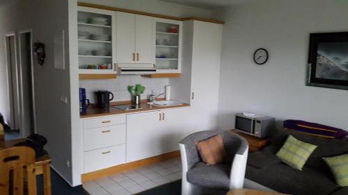 a living room with a couch and a kitchen at Parkresidenz Sanssouci in Zinnowitz