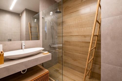 een badkamer met een wastafel en een glazen douche bij Award-winning White-spot in Athene