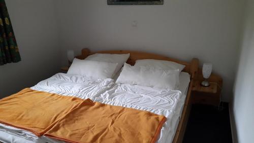ツィノヴィッツにあるParkresidenz Sanssouciの白いシーツと枕が備わるベッド1台