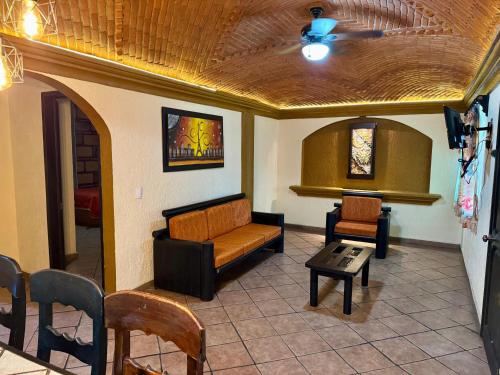 a living room with a couch and a ceiling fan at Hotel Cabañas Santa Cruz in Oaxtepec
