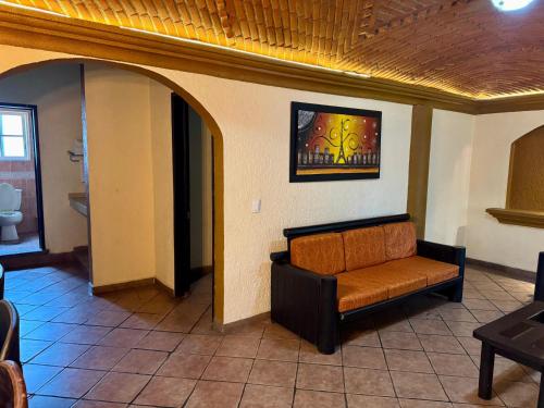 a living room with a couch in a room at Hotel Cabañas Santa Cruz in Oaxtepec