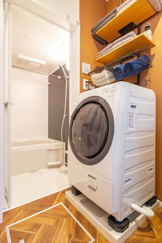 a washing machine in a room with a refrigerator at Home Suite Home Ikejiri - Shibuya 1 Stop! Sleek Confort with Washer and Dryer in Tokyo
