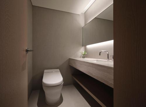 a bathroom with a white toilet and a sink at Haevichi Hotel & Resort Jeju in Seogwipo