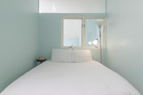 a white bed in a room with a window at 10 Guests 3BR 2BA Large Living Area & Wood Fire in Brian Head