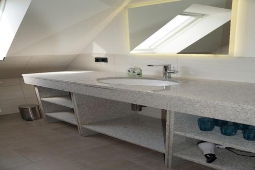 a bathroom with a sink and a mirror at Ferienhaus Sturmfrei auf Fehmarn in Kopendorf