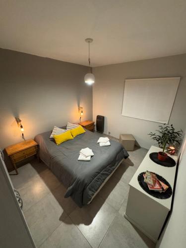 Un dormitorio con una cama grande con almohadas amarillas. en Casa Serena Rio, en Viedma
