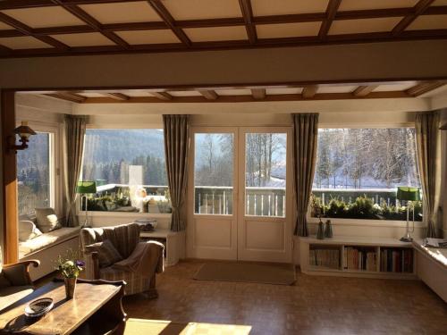 a living room with large windows and a door at Holiday home Waldhaus am Burbach in Bad Berleburg