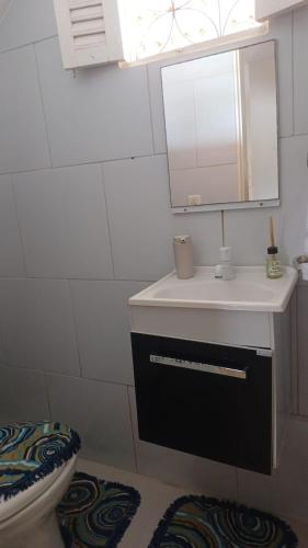 a bathroom with a sink and a mirror and a toilet at Recanto do Ze Bonito in Jacumã