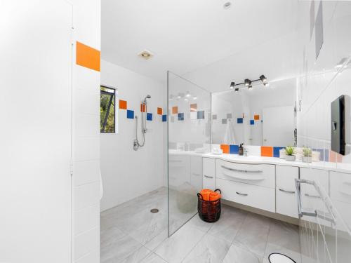 パイヒアにあるVilla Palms Paihiaのバスルーム(ガラス張りのシャワー、白いキャビネット付)