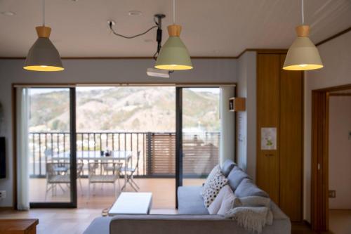 a living room with a blue couch and two lights at 天然温泉-富士山パノラマビュー-プライベートデッキで非日常体験を-伊豆の温泉付き貸別荘-中伊豆noie in Izu
