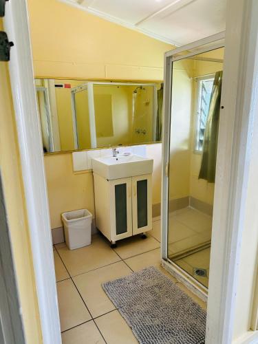 a small bathroom with a sink and a shower at Exchange Hotel Backpacker Resort in Mossman