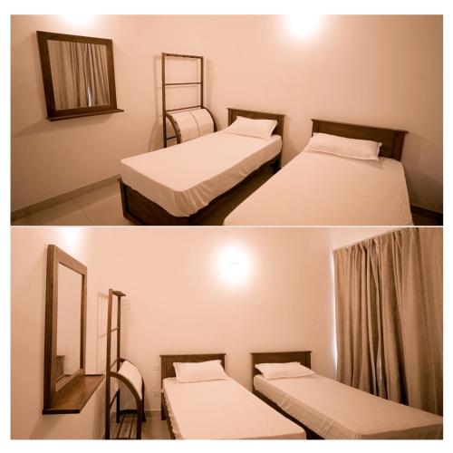 a room with two beds and a mirror at Diyawanna Villa - Deluxe Twin Room in Colombo in Sri Jayewardenepura Kotte