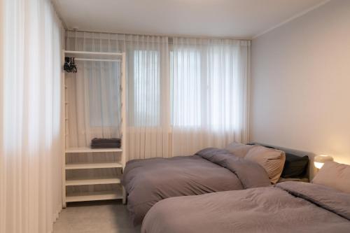 a bedroom with two beds next to a window at Manoa Garden in Seoul
