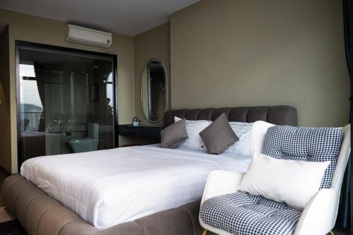 a bedroom with a large bed and a chair at C-S-J TOWER - Luxury Near Beach Apartments - Căn Hộ Du Lịch Cạnh Biển Thành Phố Biển Vũng Tàu in Vung Tau