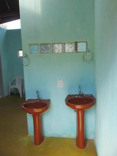 two red sinks in a room with a wall at Camping aldeia- traga seu equipamento de camping in Alto Paraíso de Goiás