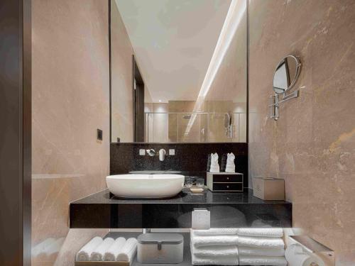 a bathroom with a sink and a mirror at Eaton Hotel Dalian Airpot & HSR Station in Jinzhou