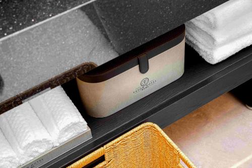 a drawer with a box of towels on a shelf at Eaton Hotel Dalian Airpot & HSR Station in Jinzhou
