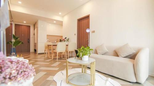 a living room with a couch and a table at THE METROPOLE Apartment Complex OPERA-GALLERIA-CREST in Ho Chi Minh City
