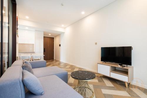 a living room with a couch and a flat screen tv at THE METROPOLE Apartment Complex OPERA-GALLERIA-CREST in Ho Chi Minh City