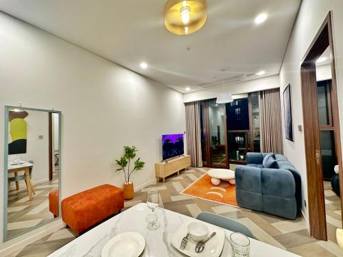 a living room with a blue couch and a tv at THE METROPOLE Apartment Complex OPERA-GALLERIA-CREST in Ho Chi Minh City