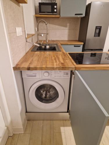 a kitchen with a washing machine under a sink at Appartement au centre de Gosier 2 in Le Gosier