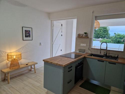 a kitchen with a sink and a table with a lamp at Appartement au centre de Gosier 2 in Le Gosier
