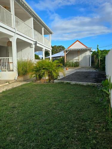 a house with a lawn in front of it at Appartement au centre de Gosier 2 in Le Gosier