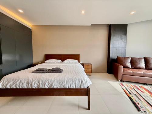 a bedroom with a bed and a couch at Escape Condominiums Beachfront Suites - Mae Phim in Rayong