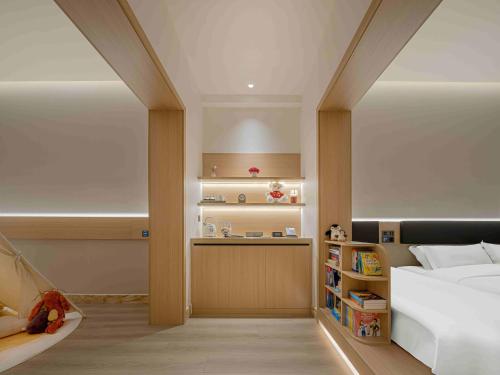 a bedroom with a bed and a book shelf at Eaton Hotel Dalian Airpot & HSR Station in Jinzhou