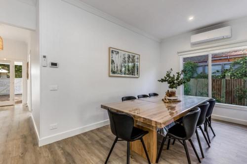 a dining room with a wooden table and chairs at 3BR Home 1km From Bendigo's CBD in Bendigo