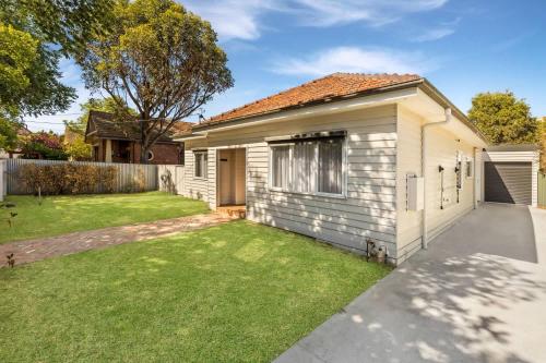 a white house with a lawn in front of it at 3BR Home 1km From Bendigo's CBD in Bendigo