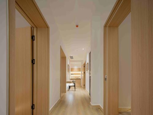 a hallway with wooden doors and a room with a table at Eaton Hotel Dalian Airpot & HSR Station in Jinzhou