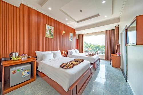 Una habitación de hotel con dos camas y un televisor. en Venus Hotel, en Ho Chi Minh