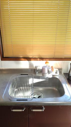 a kitchen sink with a drying rack next to it at こにべ一軒家プライベートロッジ in Miyazaki