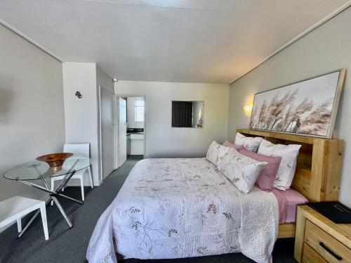 a bedroom with a large bed and a table at Heart of Christchurch City Studio in Christchurch