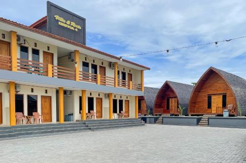 a row of buildings with tables and chairs at RedDoorz Plus at Pantai Sayangheulang Garut in Cilauteureun