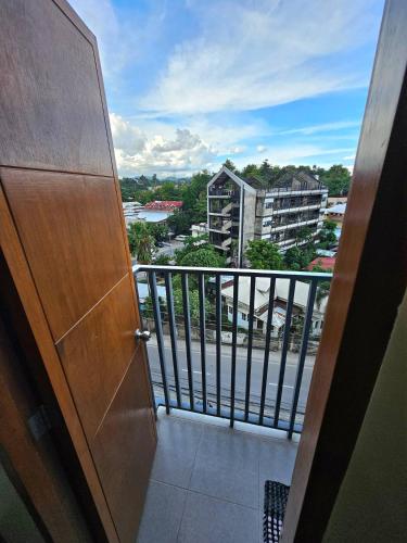 a door to a balcony with a view of a city at Elegant Studio with balcony unit 625 - 6th floor - near Ateneo De Cebu - High speed internet - Northwoods Place in Mandaue City