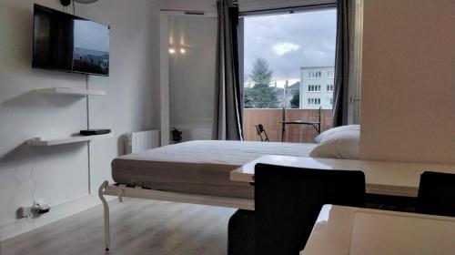 une chambre avec un lit et une grande fenêtre dans l'établissement Studio du Quai, à Château-Thierry