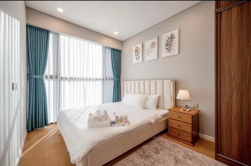 a bedroom with a large white bed and a window at THE METROPOLE Apartment Complex OPERA-GALLERIA-CREST in Ho Chi Minh City