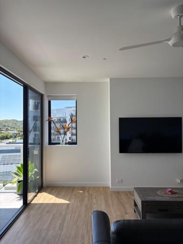 a living room with a large flat screen tv on a wall at The Arthur Apartments in Coffs Harbour