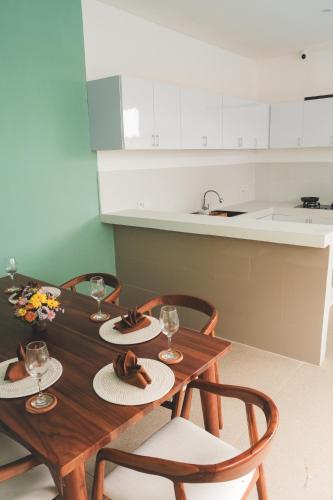 a wooden table with four chairs and a kitchen at Evara Lifestyle Villa by Aayan in Tabanan