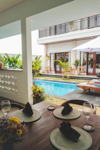 a wooden table with two hats on top of it at Evara Lifestyle Villa by Aayan in Tabanan